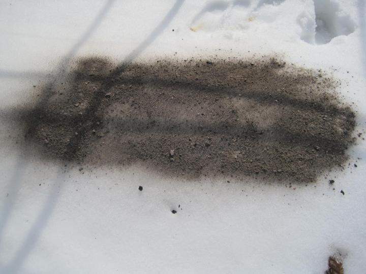 cendres de bois sur la neige pour réchauffer la terre du jardin